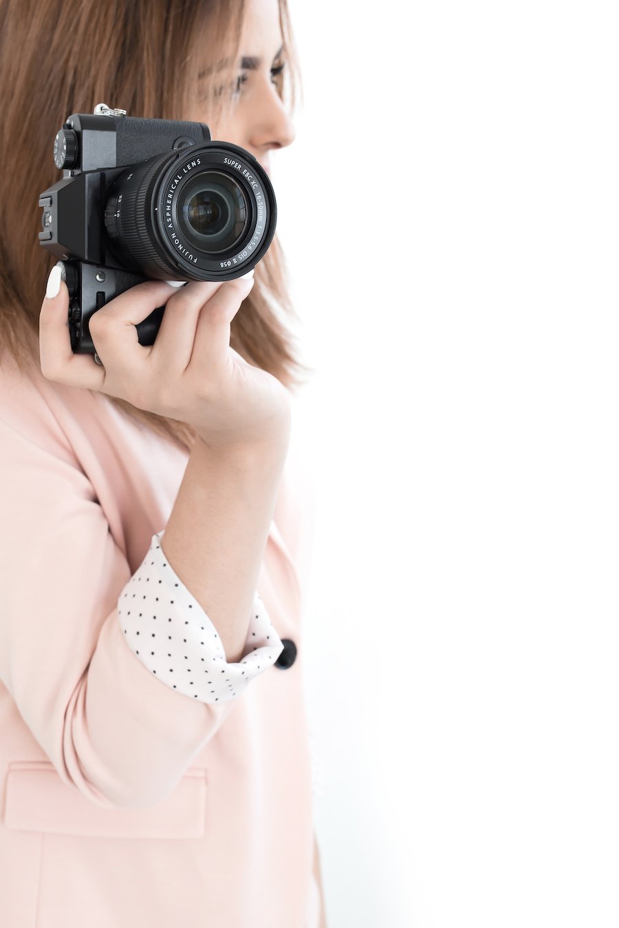 woman in pink blazer with a camera